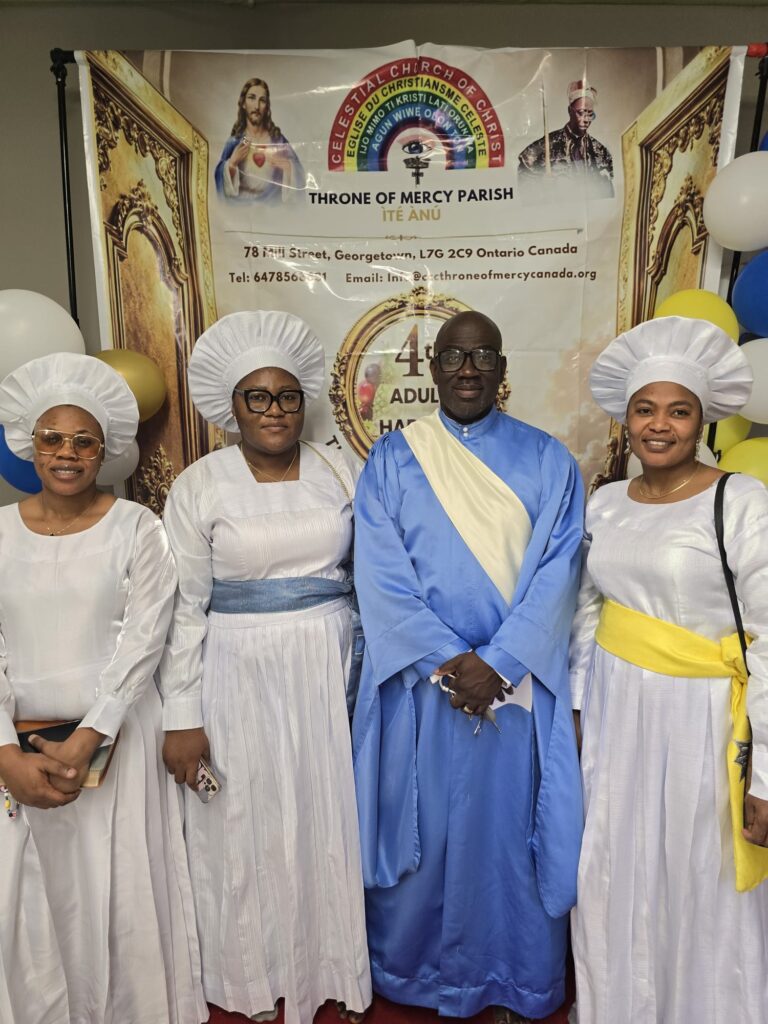 Members in white garments and head coverings with a clergy member in blue at the harvest banner