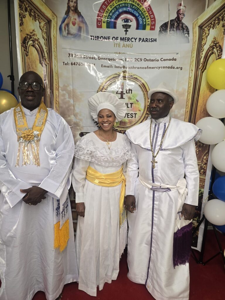 Three celebrants in white garments at the 4th Adult Harvest banner