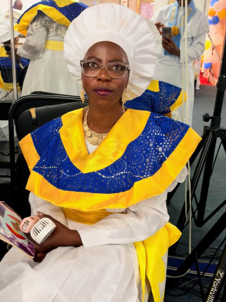 Choir member in white head-tie and blue and gold harvest collar