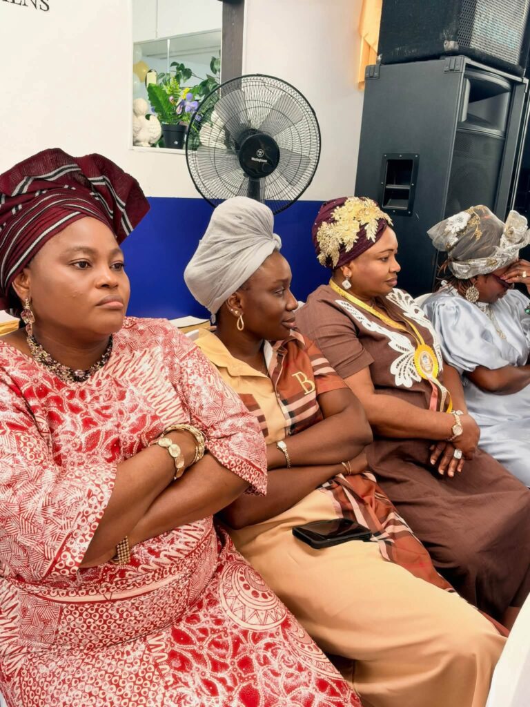 Guests in colourful traditional attire and head wraps seated during the service