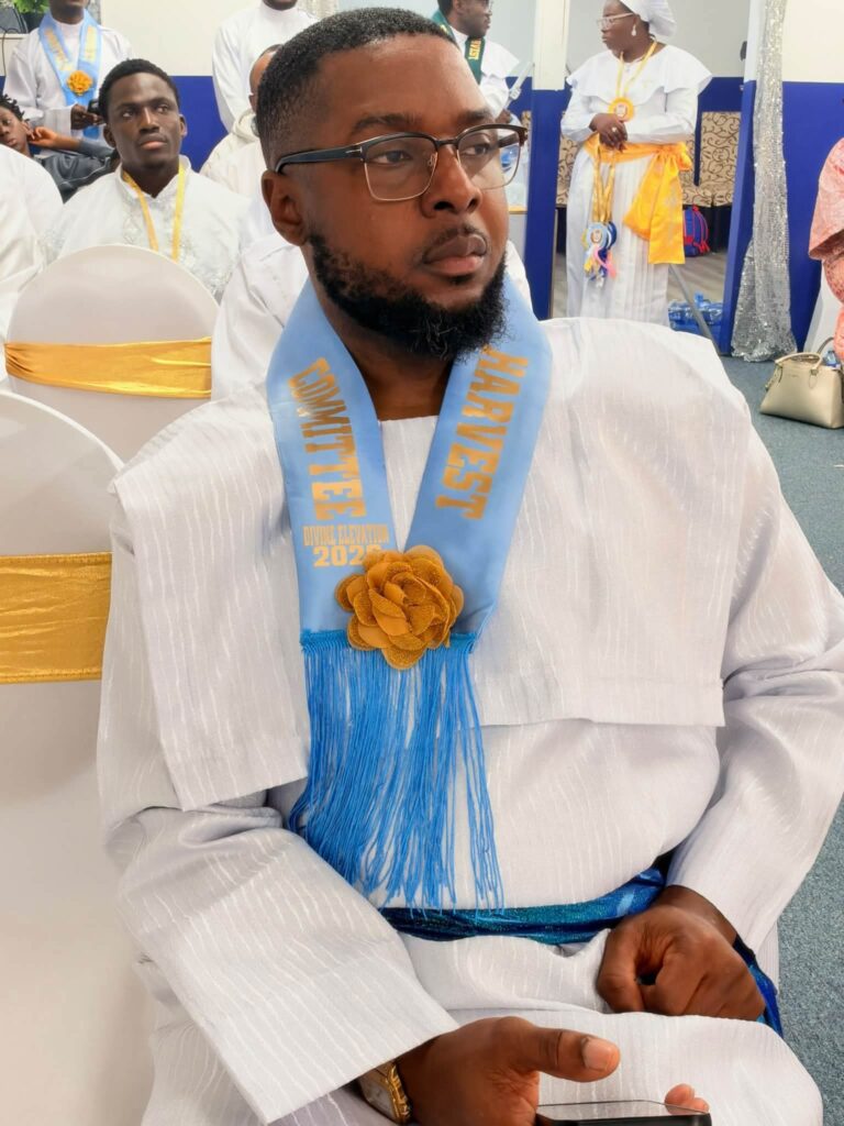 Harvest Committee member in white garment with light blue sash